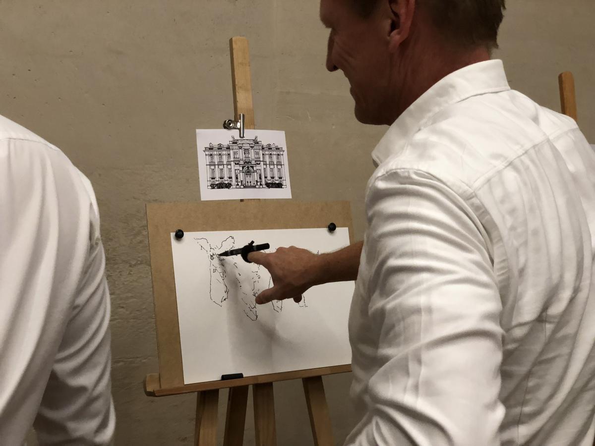 With the help of the mentalist, the participant tries to reproduce a drawing model.
